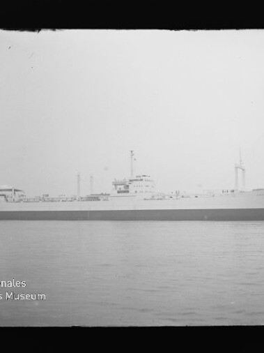 Schwarzweiß-Profil eines Frachtschiffs auf ruhiger See mit Brücke und Schornstein; Wasserzeichen des Internationalen Maritimen Museums Hamburg