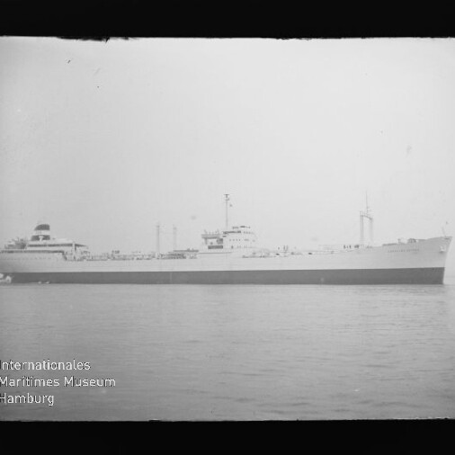 Schwarzweiß-Profil eines Frachtschiffs auf ruhiger See mit Brücke und Schornstein; Wasserzeichen des Internationalen Maritimen Museums Hamburg