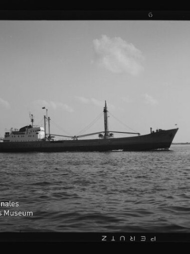 Schwarzweißaufnahme eines Frachtschiffs auf ruhiger See; links unten Logo und Schrift Internationales Maritimes Museum Hamburg.