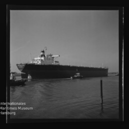 Tankschiff im Hafen, von Schleppern begleitet; Foto mit Schriftzug Internationales Maritimes Museum Hamburg