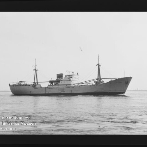 Seitliche Aufnahme eines Frachtschiffs mit zwei Masten und mittigem Aufbau auf dem Meer; Schwarzweißfoto mit Museumslogo.