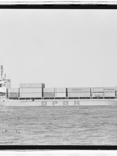 Frachtschiff mit gestapelten Containern und Schriftzug OPDR auf dem Rumpf, auf ruhiger See; Schwarzweißaufnahme mit Museumswasserzeichen.