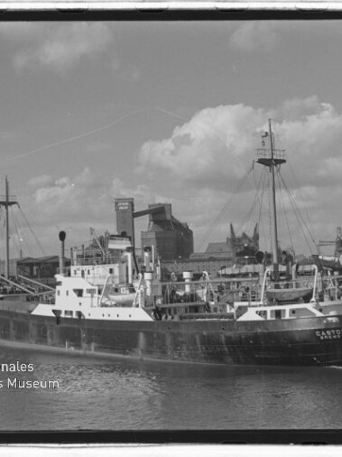 Schiff 'Castor' im Hafen vor Kaianlagen und Kränen, Museumslogo 'Internationales Maritimes Museum Hamburg' links unten.