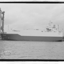 Großes RoRo-Frachtschiff liegt am Kai neben Hafenkranen, Schwarzweißaufnahme mit Wasserzeichen des Maritimen Museums.