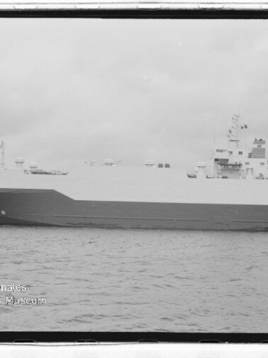 Großes RoRo-Frachtschiff liegt am Kai neben Hafenkranen, Schwarzweißaufnahme mit Wasserzeichen des Maritimen Museums.