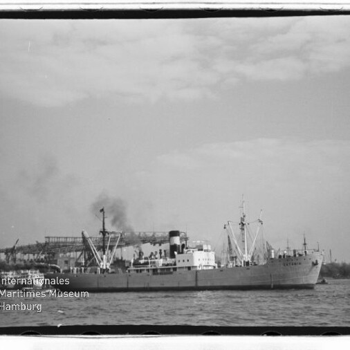 Schwarzweißfoto eines Frachtschiffs vor Hafenkränen, mit Museumslogo Maritimes Museum Hamburg links unten.