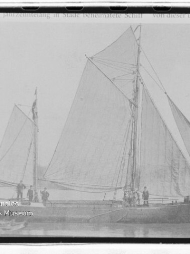 Traditionelles Segelschiff mit großen gesetzten Segeln und mehreren Personen an Deck auf ruhigem Wasser; Museumswasserzeichen.