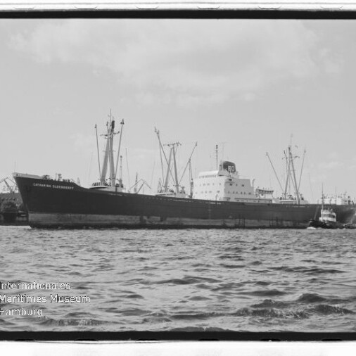 Großes Frachtschiff mit Ladekränen und kleinem Schlepper im Hafen, Schwarzweißaufnahme mit Museumswasserzeichen.