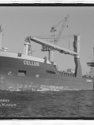 Frachtschiff CELLUS mit Ladekränen am Kai im Hafen, Wellen im Vordergrund und Museumslogo unten links.