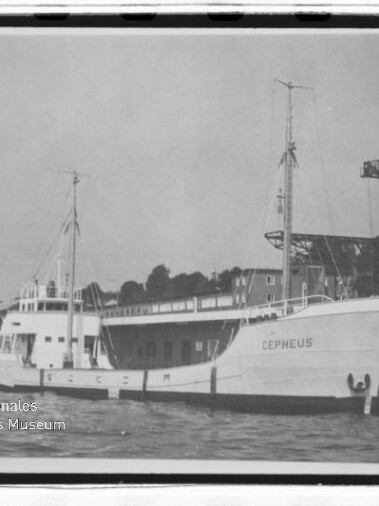 Schiff Cepheus am Kai eines Industriehafens, Bug mit Namen sichtbar, Kran und Piergebäude im Hintergrund.