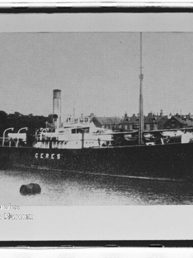 Dampfschiff CERES mit Schornstein und Masten am Kai, Häuserreihe im Hintergrund und Boje im Wasser