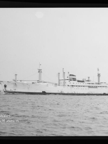 Weißes Passagier- und Frachtschiff in Seitenansicht auf ruhiger See; Wasserzeichen des Internationalen Maritimen Museums Hamburg sichtbar.
