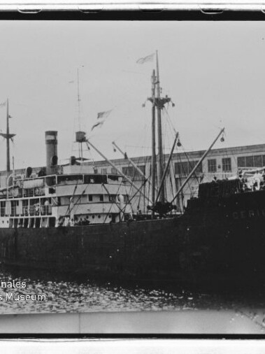 Dampfschiff mit Schornstein und Masten am Kai vor Lagerhaus; Wasserzeichen: Maritimes Museum Hamburg