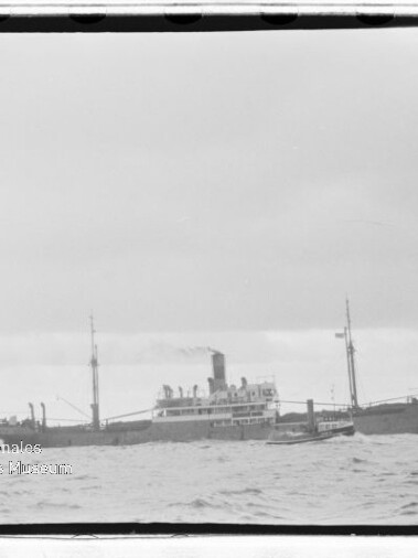 Dampfschiff mit rauchendem Schornstein und zwei Masten auf offener See; Wasserzeichen des Maritimen Museums.