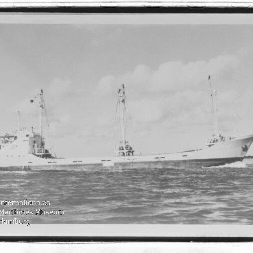 Schwarzweißfoto eines Frachtschiffs mit zwei Masten auf ruhiger See, Museumswasserzeichen unten links.