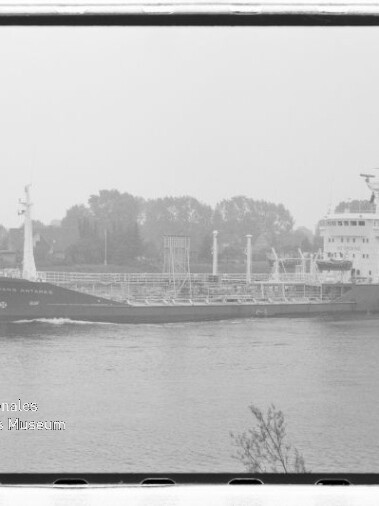 Frachtschiff mit Deckspipelines und Aufbauten fährt auf ruhigem Fluss, Wasserzeichen des Maritimen Museums Hamburg.