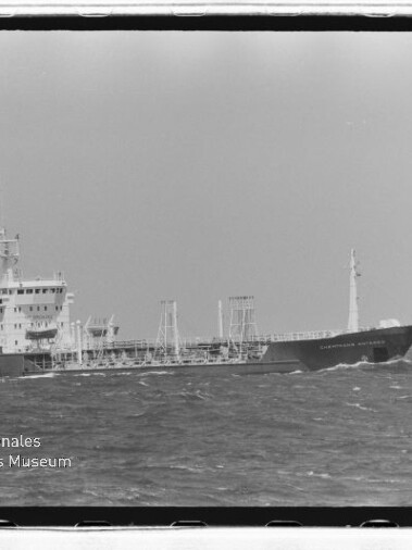 Tankterschiff mit Aufbauten achtern fährt auf offener See, im Bild unten links Museumslogo
