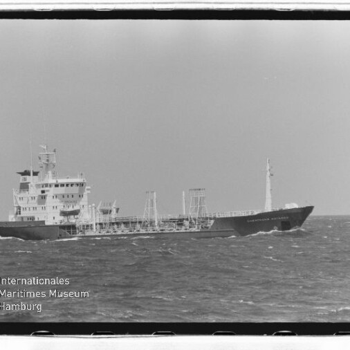 Tankterschiff mit Aufbauten achtern fährt auf offener See, im Bild unten links Museumslogo