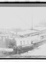 Schneebedeckter Lastkahn im Hafen mit Steuerhaus und flachem Laderaum, unten links Wasserzeichen eines Maritimen Museums.