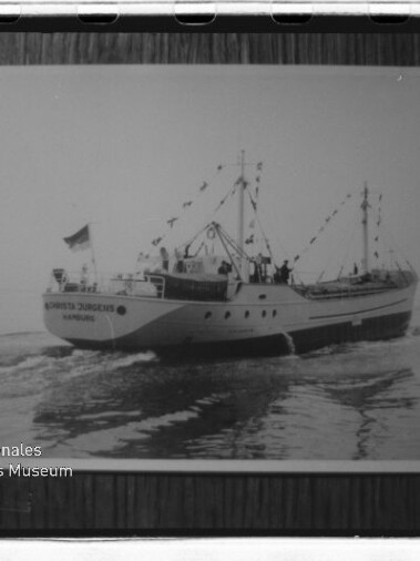 Gerahmtes Schwarzweißfoto eines geschmückten Schiffes mit Flaggen über ruhiger See und Museumswasserzeichen.