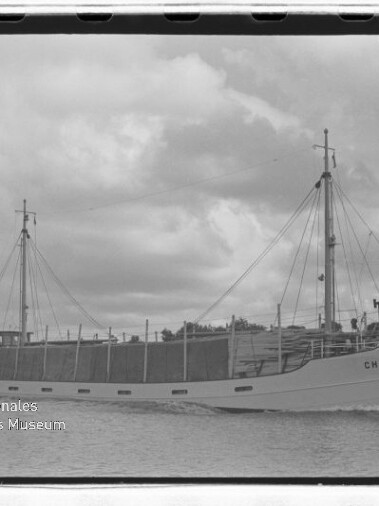 Frachtschiff Christel mit zwei Masten und beladenem Laderaum auf ruhigem Wasser unter bewölktem Himmel