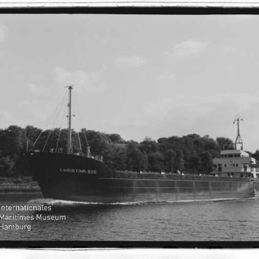 Schwarzweißfoto eines Frachtschiffs namens CHRISTINA 805, das vor einem baumbewachsenen Ufer fährt; Museumslogo unten links.