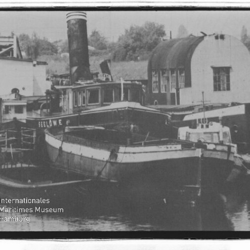 Alte Schiffe, darunter ein Dampfer mit hohem Schornstein, liegen im Hafen; Schriftzug Maritimes Museum Hamburg sichtbar.