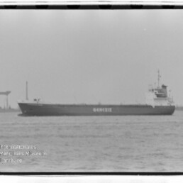 Frachtschiff mit Schriftzug GENESIS auf ruhiger See, Hafenkran im Hintergrund, schwarzweißfotografie.