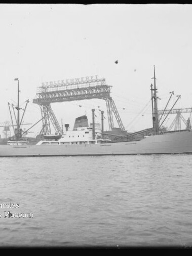 Frachtschiff Alaska am Hafen vor großen Ladekränen und Kaimauern, ruhige See