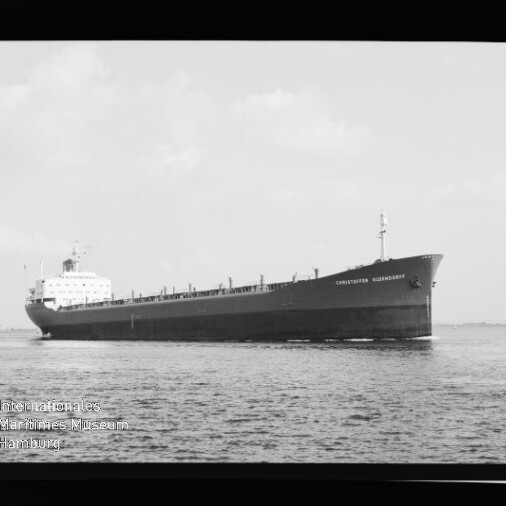 Langes Massengutfrachtschiff in Seitenansicht fährt ruhig über das Meer, Schiffsnamen auf dem Bug sichtbar.