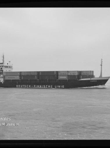 Schwarzweißfoto eines Containerschiffs mit der Aufschrift Deutsch-Finnische Linie auf ruhiger See, Stapelcontainer und Steuerhaus sichtbar.