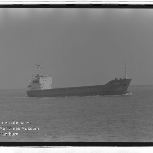 Frachtschiff in Seitenansicht auf ruhiger See mit leichter Heckwelle; Wasserzeichen 