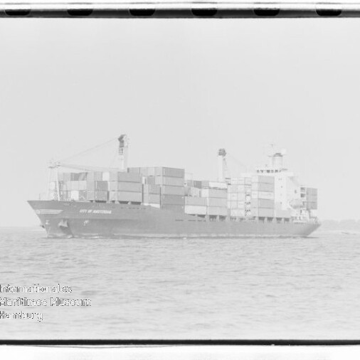 Containerschiff mit gestapelten Containern auf ruhiger See; Wasserzeichen des Internationalen Maritimen Museums Hamburg.