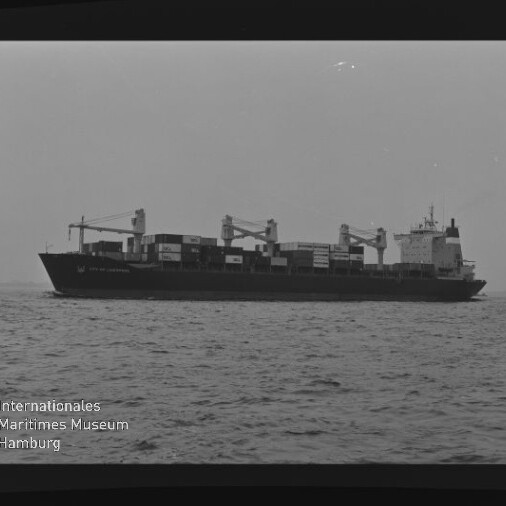 Containerschiff mit gestapelten Containern und Kränen auf ruhiger See; Schriftzug 'Internationales Maritimes Museum Hamburg'