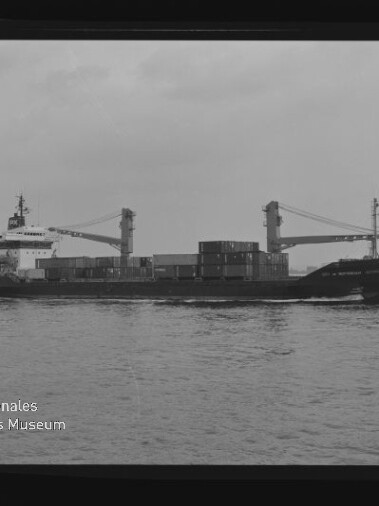 Schwarzweißfoto eines Frachtschiffs mit Containern und zwei Kränen auf ruhiger See; Wz: Maritimes Museum Hamburg