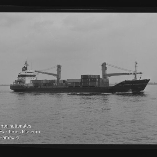Schwarzweißfoto eines Frachtschiffs mit Containern und zwei Kränen auf ruhiger See; Wz: Maritimes Museum Hamburg