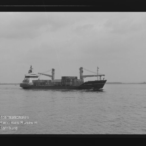 Frachtschiff mit Ladekränen und Containern auf ruhiger See unter bewölktem Himmel; Wasserzeichen Internationales Maritimes Museum Hamburg.
