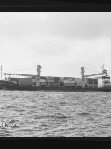 Schwarzweißaufnahme eines Containerschiffs auf See mit Containerstapel, Filmrand und AGFA PAN 100-Markierung.