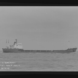 Frachtschiff in Seitenansicht auf ruhiger See, Schwarzweißfilm mit sichtbarem 