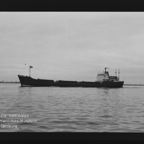Sicht seitlich auf ein Frachtschiff in ruhiger See, klare Silhouette vor hellem Himmel; Museumslogo unten links.