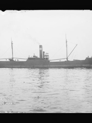 Seitliche Ansicht eines Dampffrachters mit Schornstein und zwei Masten auf ruhiger See; Wasserzeichen: Maritimes Museum Hamburg