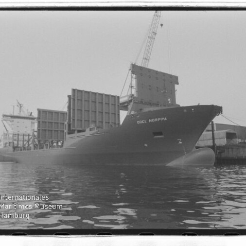 Schwarzweißaufnahme: Containerschiff OOCL NORPPA am Kai, beladene Containerstapel, Hafenkran und Spiegelung im Wasser.