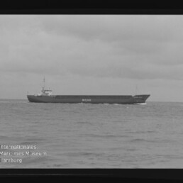 Frachtschiff ECHO fährt bei ruhiger See unter bewölktem Himmel, seitliche Ansicht.