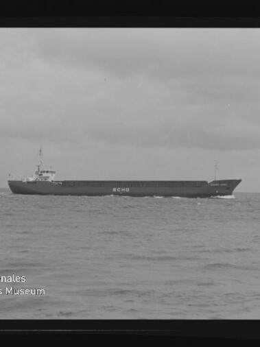 Frachtschiff ECHO fährt bei ruhiger See unter bewölktem Himmel, seitliche Ansicht.