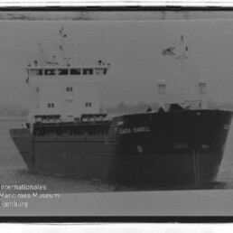 Frachtschiff Klaudia Isabell in leicht frontaler Ansicht auf ruhiger See, schwarz-weiß-Foto mit Museumswasserzeichen