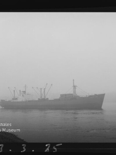 Frachtschiff im dichten Nebel auf ruhigem Wasser, mit Internationales Maritimes Museum Hamburg‑Logo unten links.