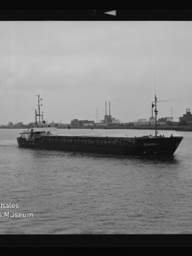 Frachtschiff „CLAUDIA K.“ fährt auf ruhigem Fluss, im Hintergrund Industrieanlagen mit hohen Schornsteinen