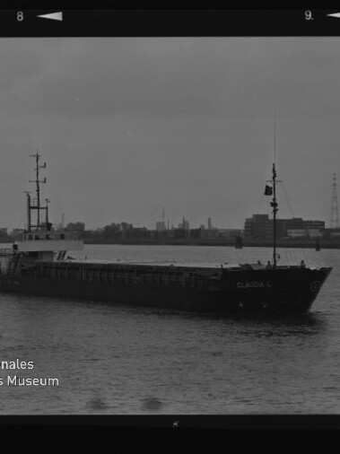 Schwarzweißfoto eines Frachtschiffs vor einem Industriehafen mit Wasserzeichen des Maritimen Museums Hamburg.