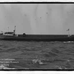 Seitenansicht eines Frachtschiffs auf leicht bewegter See, schwarzweiß-Foto mit Schriftzug Internationales Maritimes Museum Hamburg
