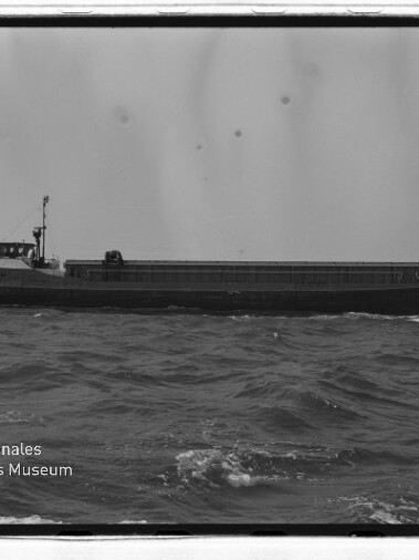 Seitenansicht eines Frachtschiffs auf leicht bewegter See, schwarzweiß-Foto mit Schriftzug Internationales Maritimes Museum Hamburg